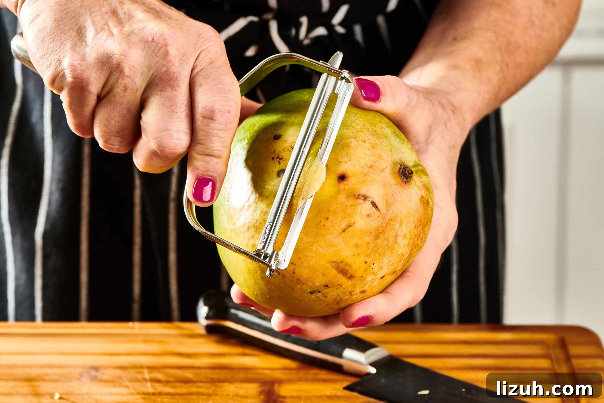 How to Cut a Mango Like a Pro: Quick Step-by-Step Guide 5 Woman using a peeler to peel a mango.