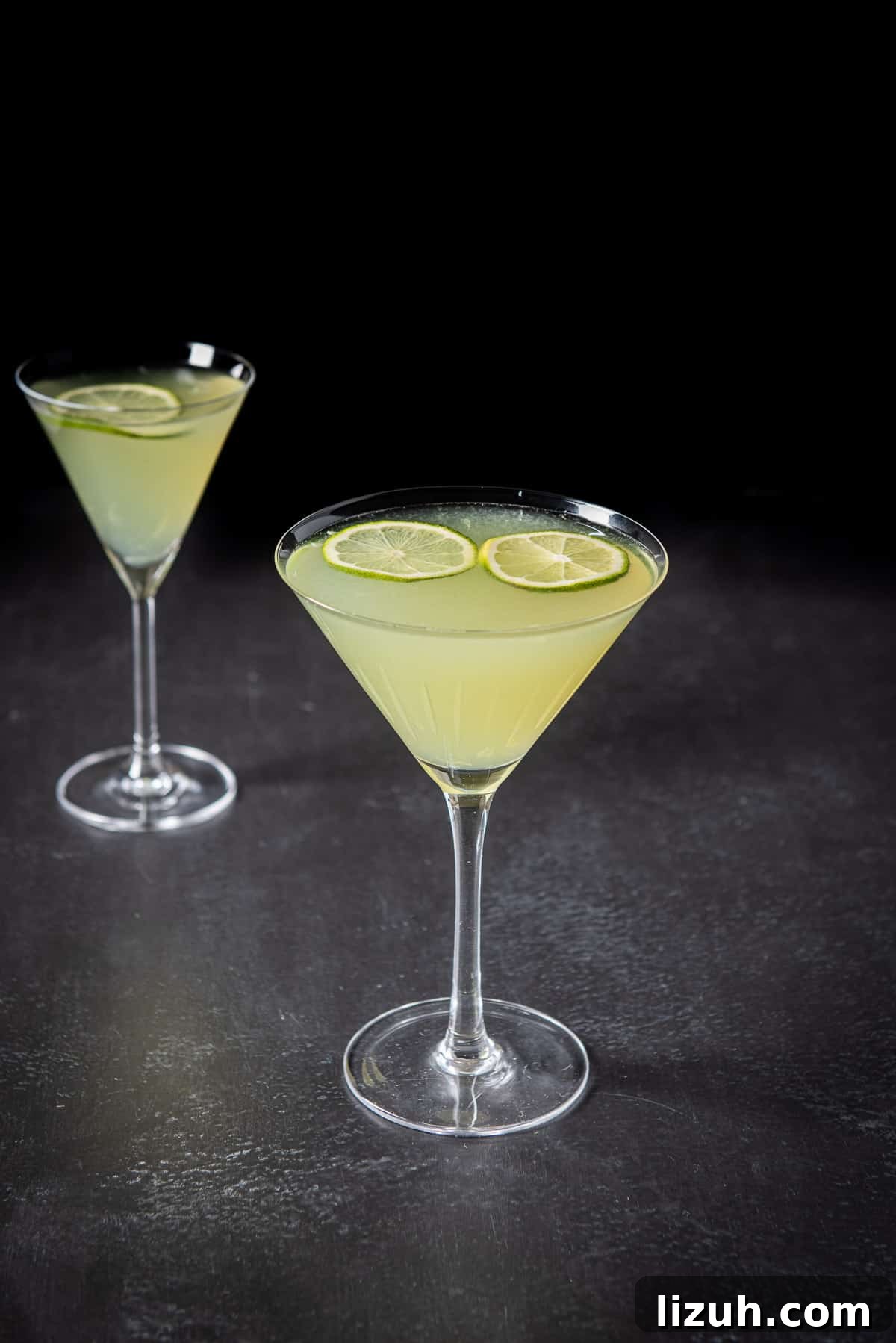 Classic Last Word Cocktail Recipe: How to Mix the Prohibition-Era Drink 2 Two glasses filled with a lime cocktail with two thin lime wheels floating