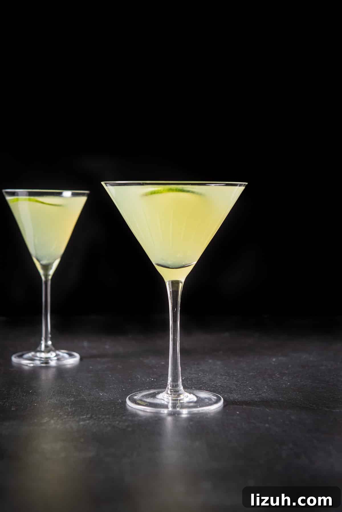 Classic Last Word Cocktail Recipe: How to Mix the Prohibition-Era Drink 7 Vertical view of the glasses filled with the lime cocktail with slices of lime floating