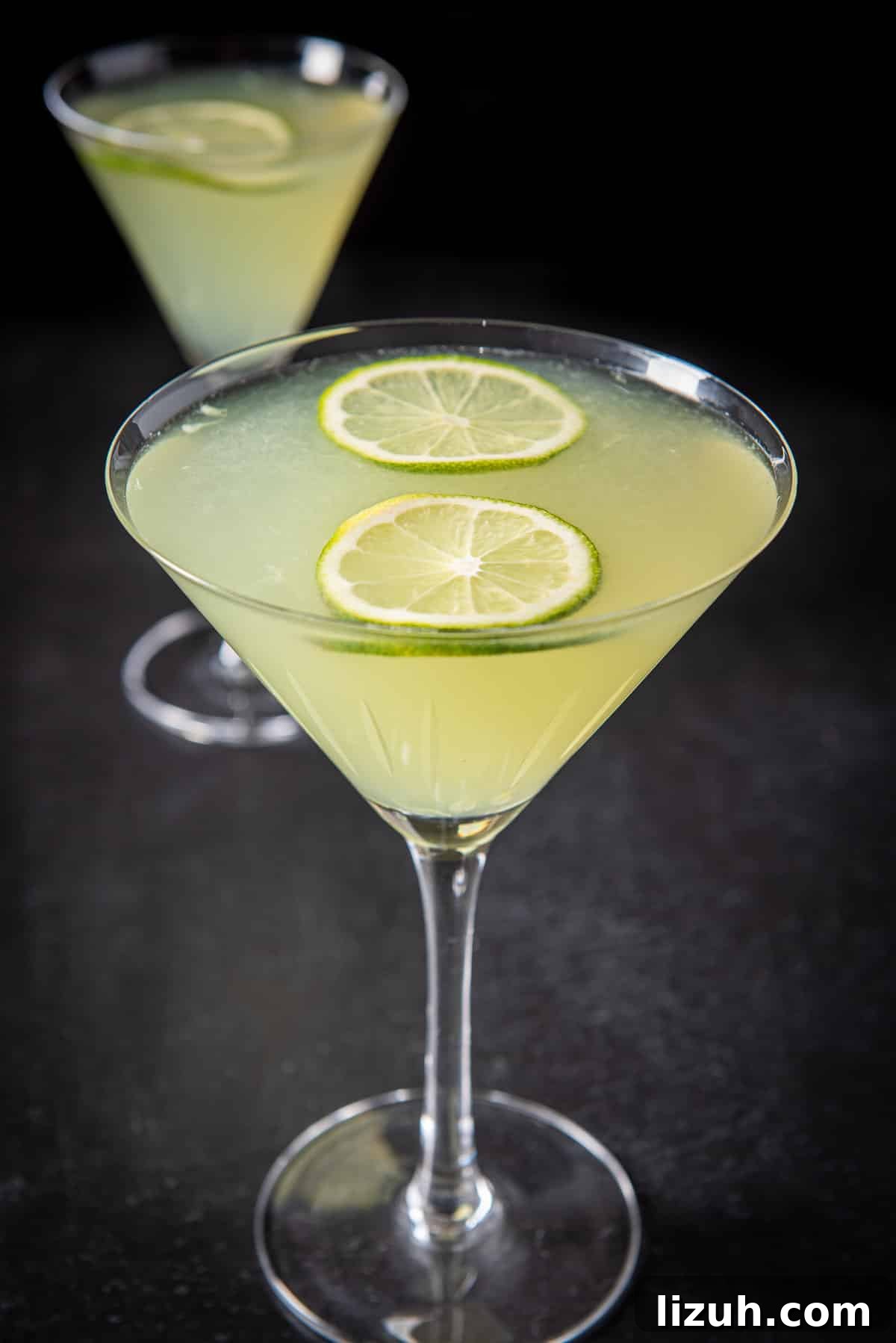 Classic Last Word Cocktail Recipe: How to Mix the Prohibition-Era Drink 8 Close up of a lime cocktail in martini glasses with limes floating on the top