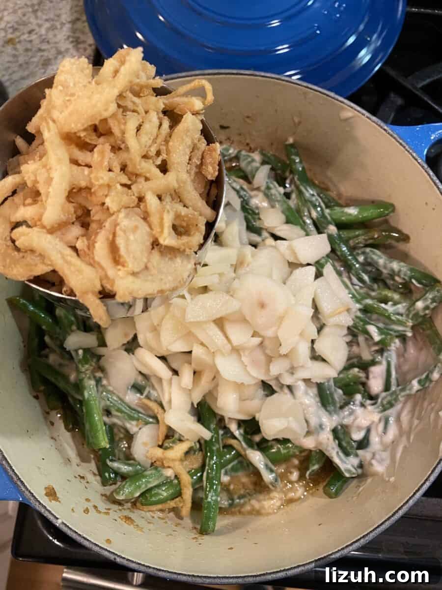 Green beans, water chestnuts and fried onions in a pan on the stove.