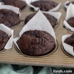Chocolate sourdough zucchini muffins in a muffin tin.