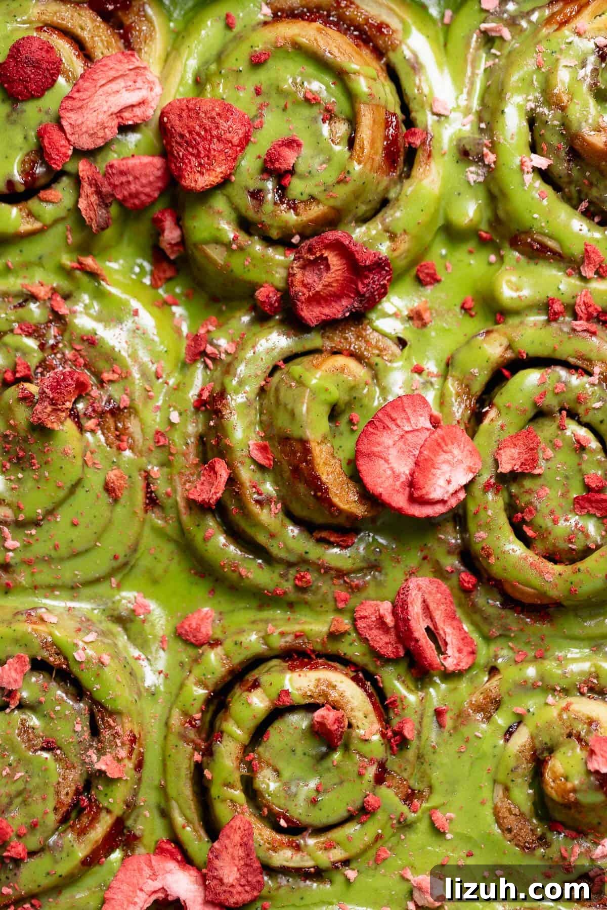 Matcha cinnamon rolls with strawberry filling and freeze dried strawberries on top.