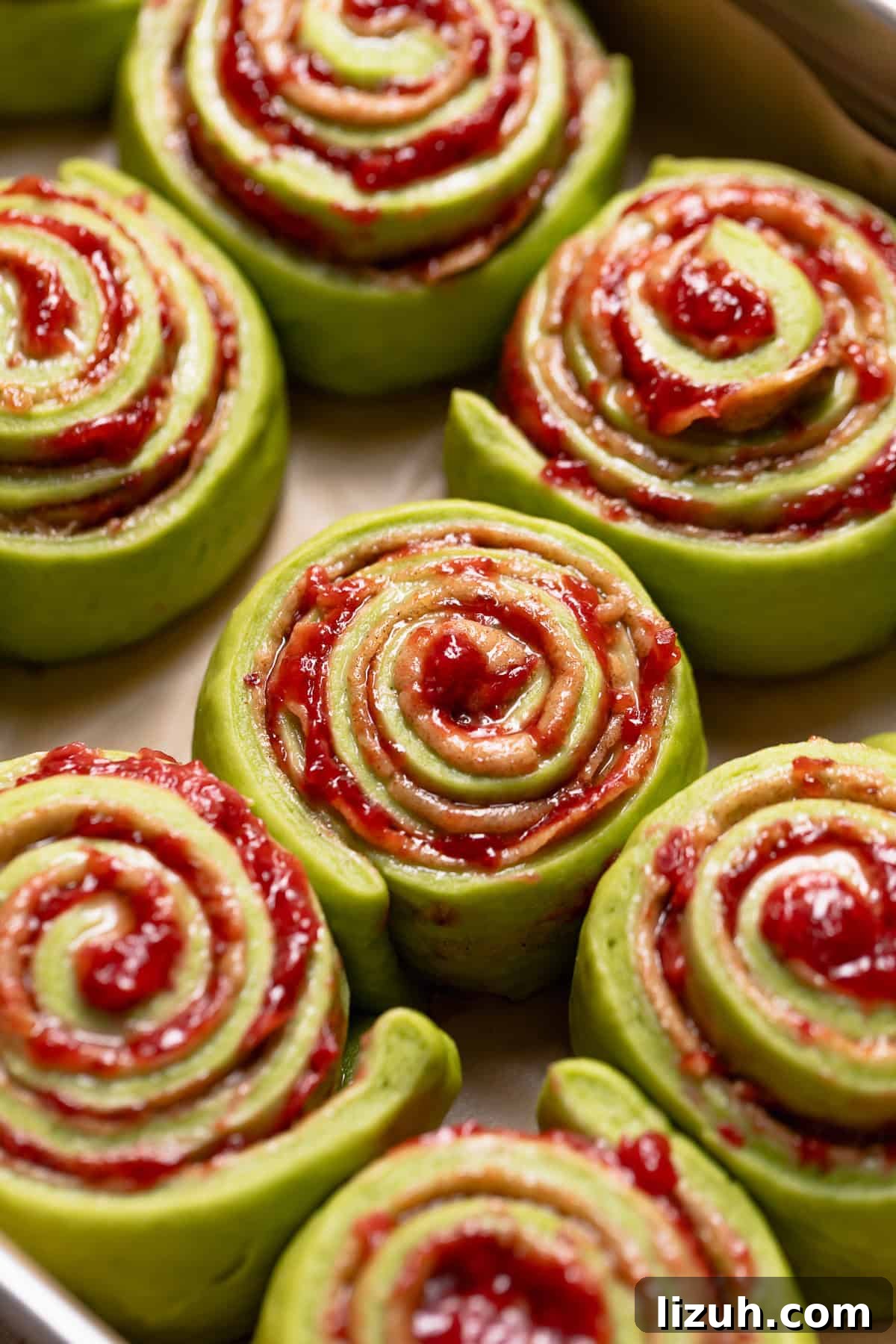 Matcha rolls doubled in size and ready to bake in a baking pan.