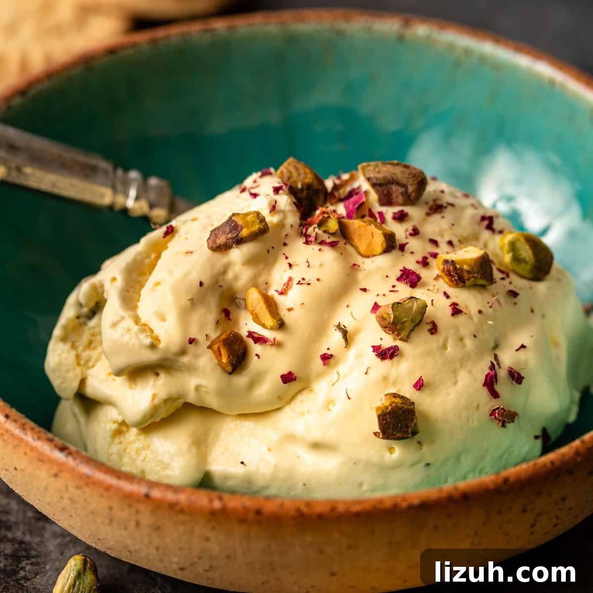 closeup: a bowl of persian ice cream with crushed pistachios and rose petals on top
