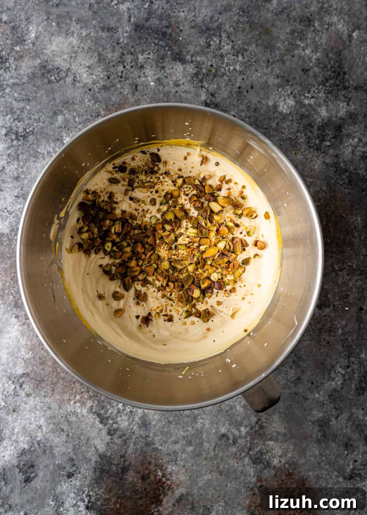 overhead process shot: adding crushed pistachios to the saffron ice cream mixture