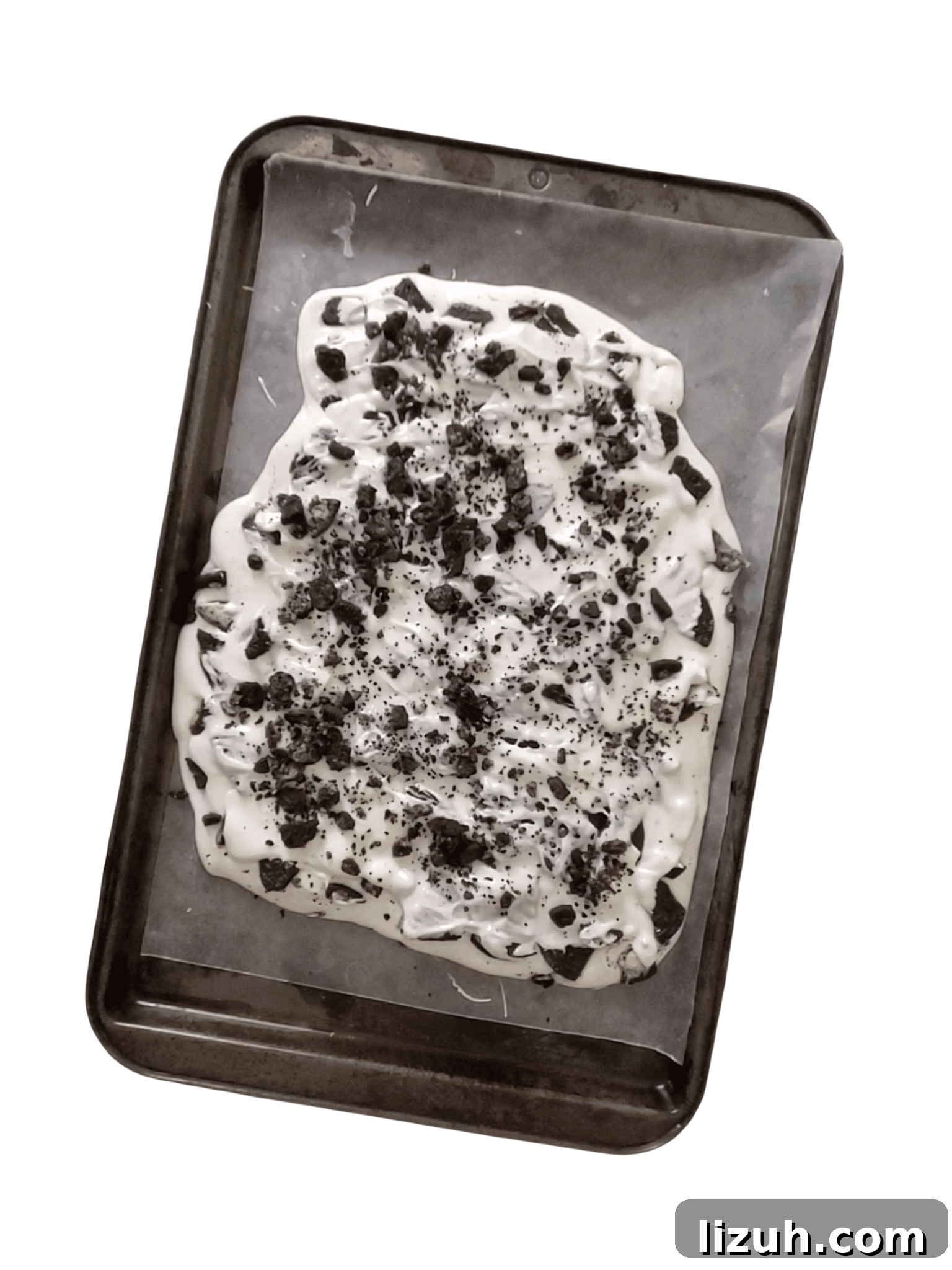 Oreo Cookies and Cream Bark Recipe: No-Bake Dessert Recipe 5 oreo cookies being spread in white chocolate