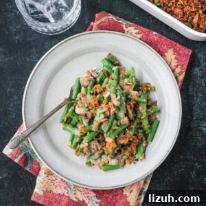 Serving of vegan green bean casserole on a plate with a fork.