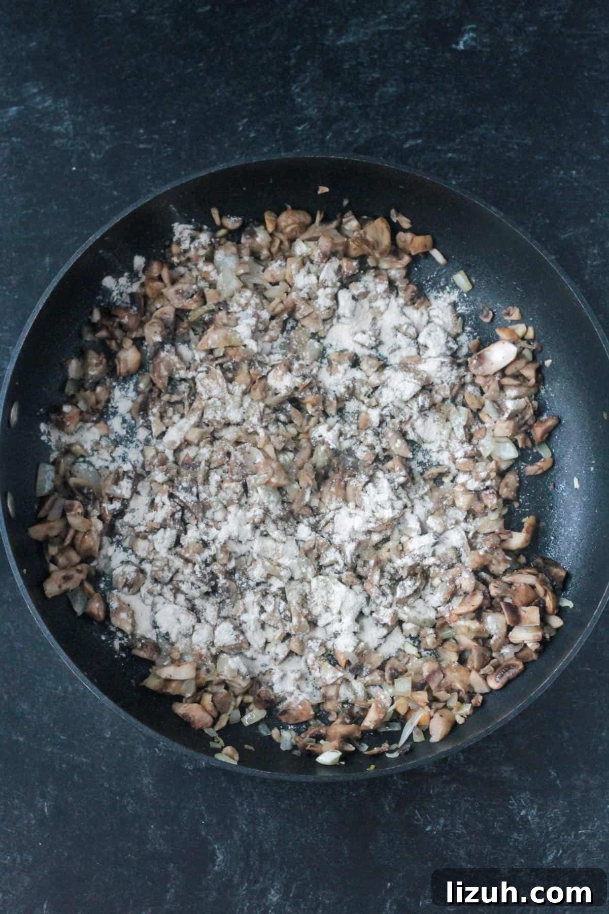 Flour sprinkled on top of the cooked mushrooms.