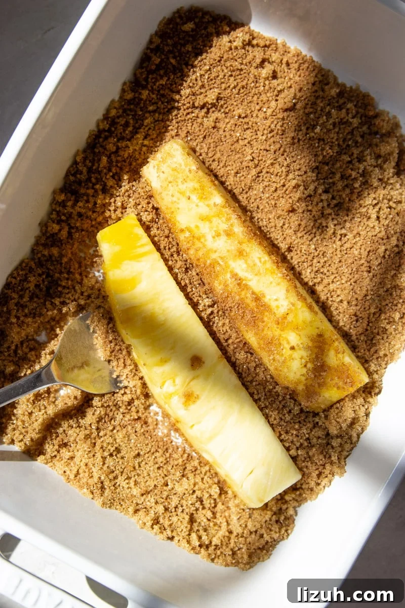 Brazilian-Style Grilled Pineapple Recipe for Sweet Tangy Dessert 4 Pineapple being coated with cinnamon and brown sugar.
