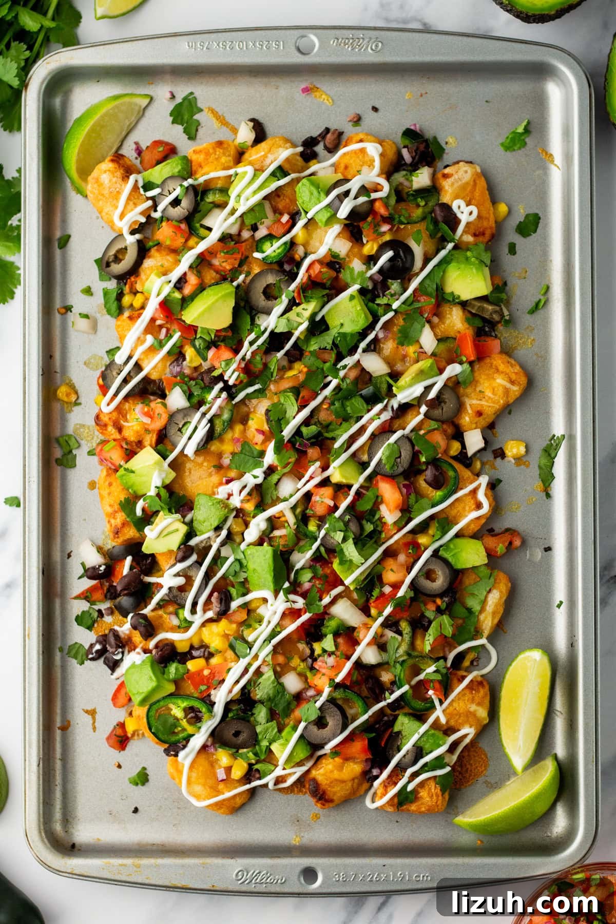 Loaded Tater Tot Nachos with Cheesy Beef and Jalapeños 2 An overhead image of lime juice, fresh avocados, and fresh cilantro.