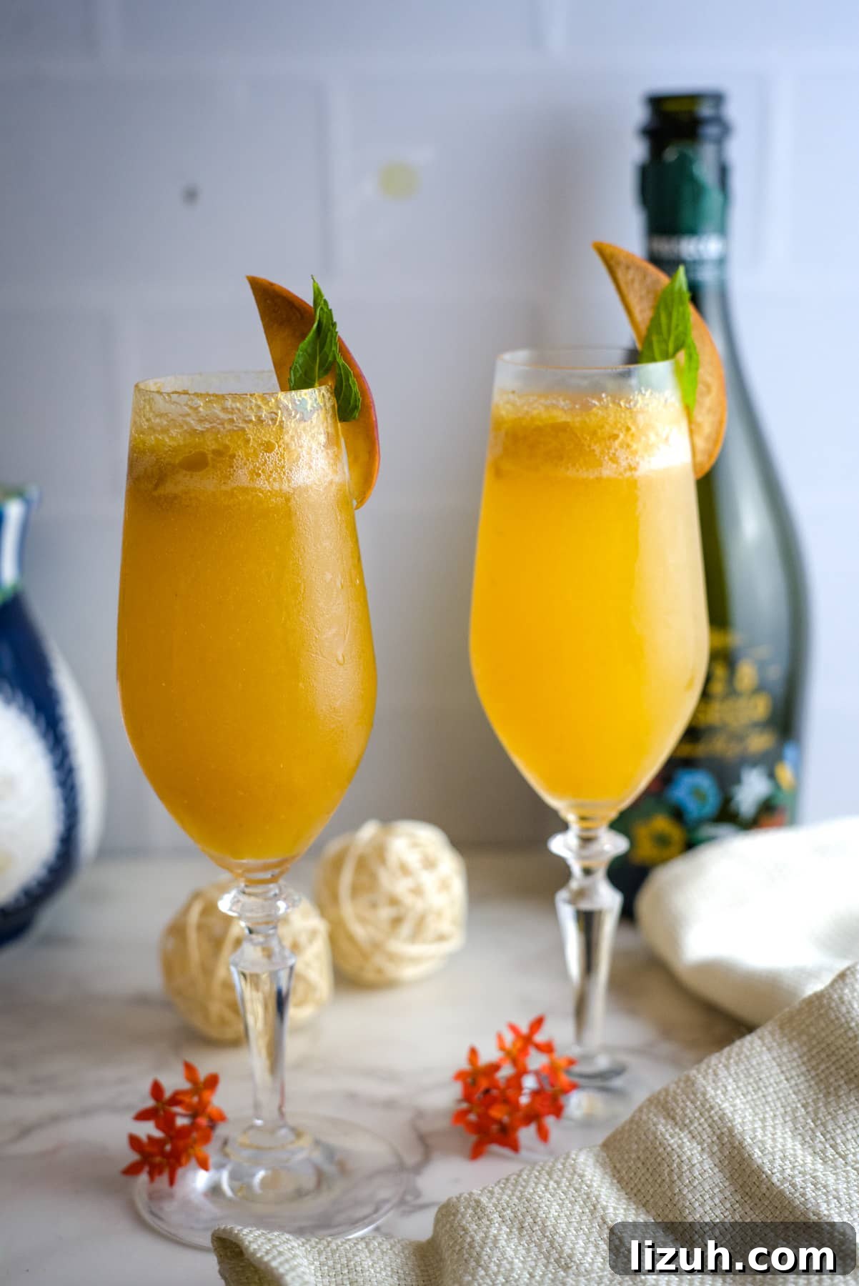 two glasses of peach bellini with a garnish