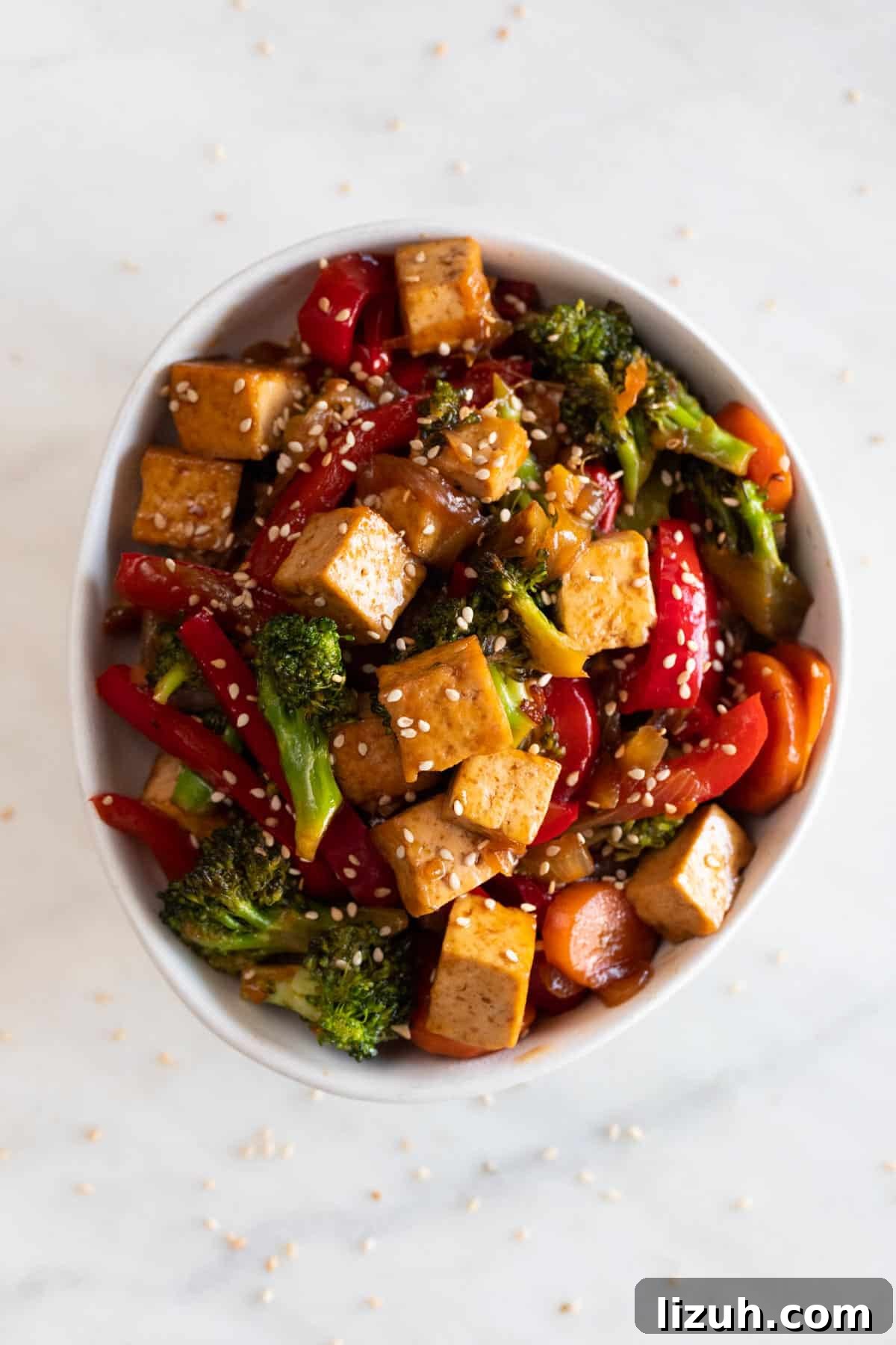 29 Authentic Vegan Chinese Recipes for Flavorful Plant-Based Meals 12 A bowl with tofu stir fry garnished with some sesame seeds.