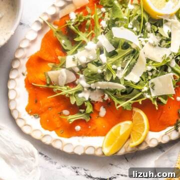 Salmon carpaccio appetizer with arugula and parmesan.