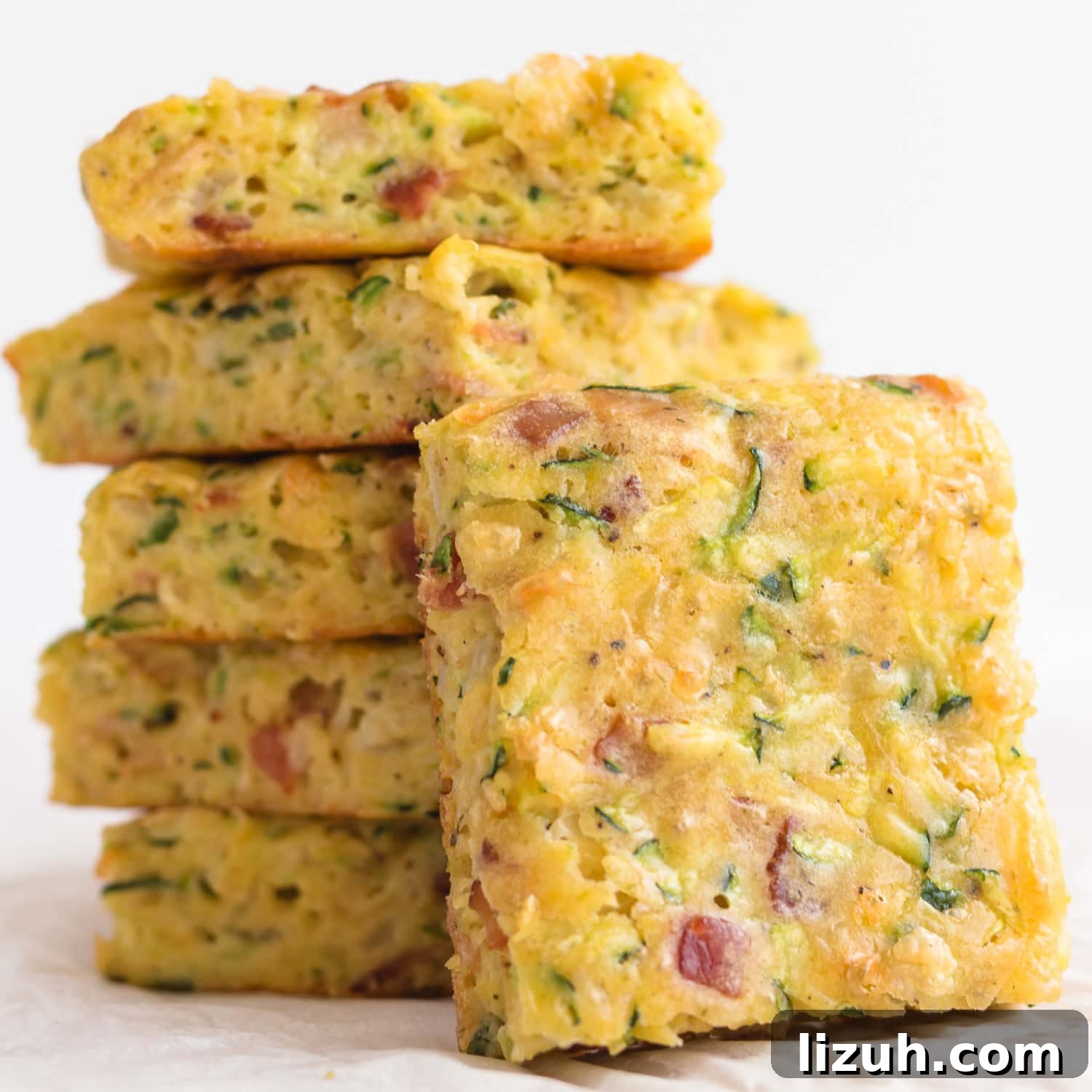 Savory Zucchini Slice Recipe with Cheesy Herb Crust 11 Pile of zucchini slice with one piece leaning against it.
