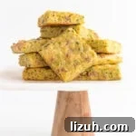 Pile of zucchini slice on a marble and wood cake stand.