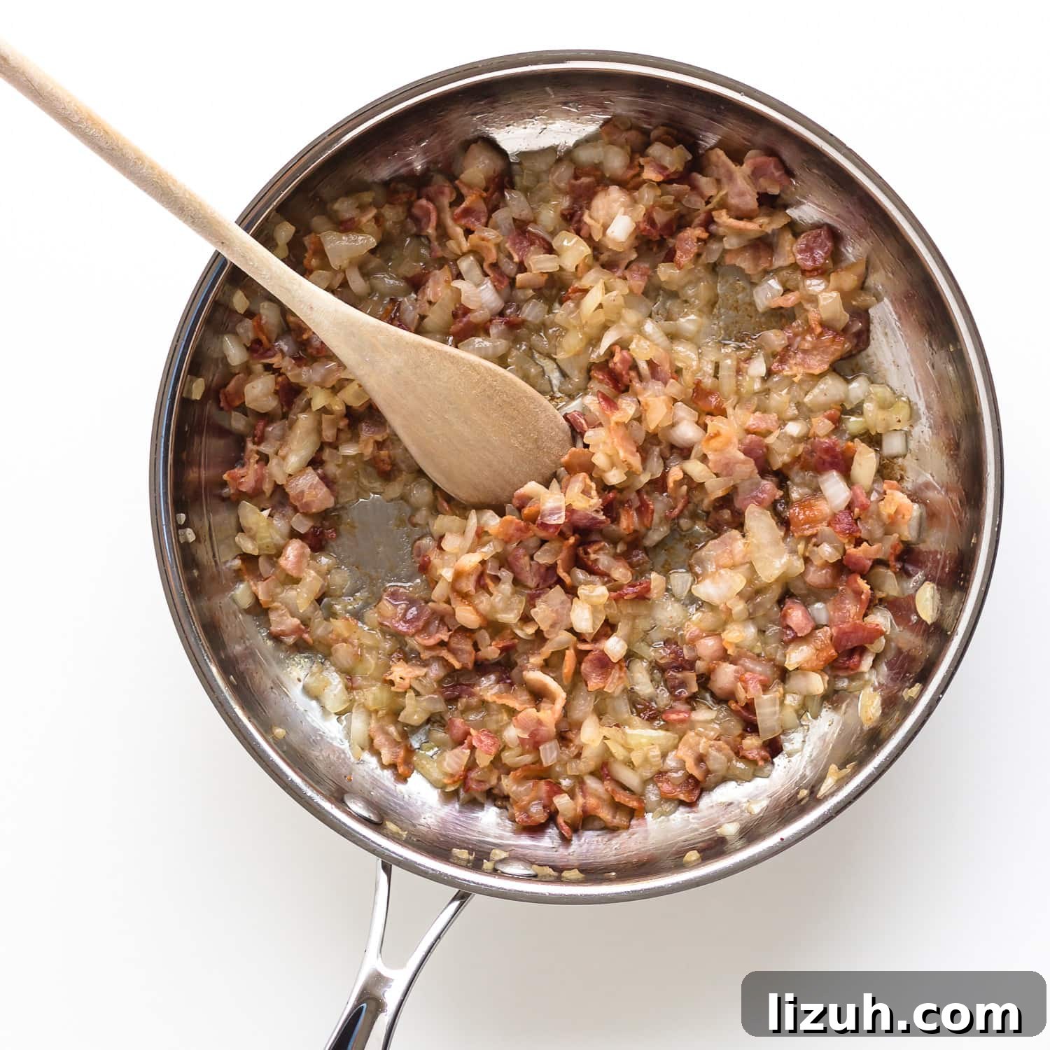 Savory Zucchini Slice Recipe with Cheesy Herb Crust 6 Sautéed bacon and onions in a stainless steel frying pan.