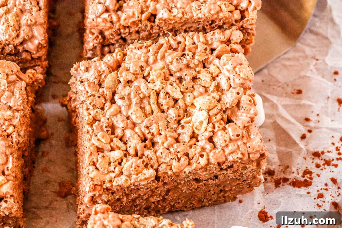 Thick Chewy Chocolate Rice Krispies Treats Recipe 3 A chocolate rice crispy treat on a serving platter.