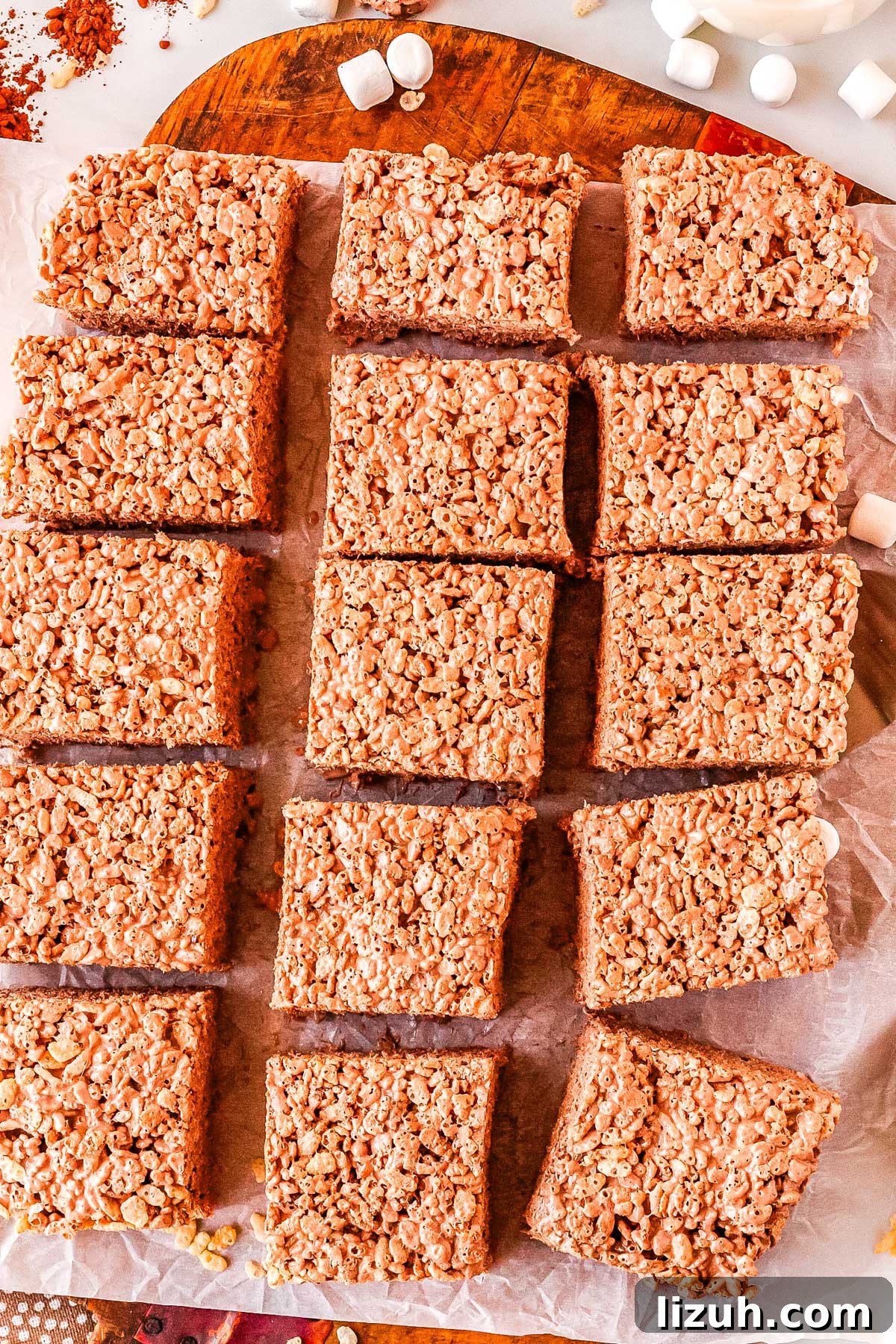Thick Chewy Chocolate Rice Krispies Treats Recipe 9 15 cut chocolate rice crispy treats on a wooden serving platter.