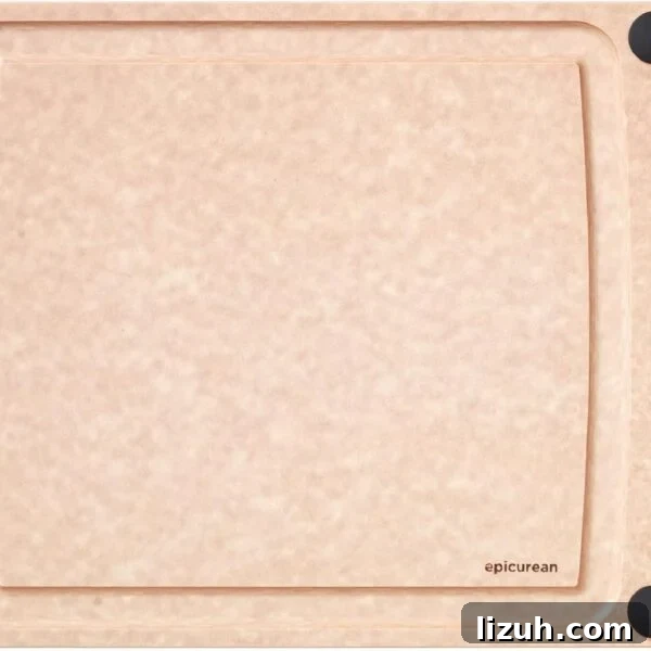 A rectangular, light brown cutting board with a smooth surface, four black non-slip corners, and a small hole on the left side.