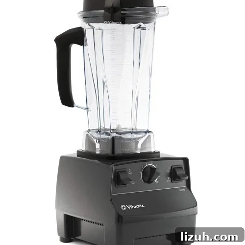 A black Vitamix blender with a clear plastic pitcher, black lid, and handle.