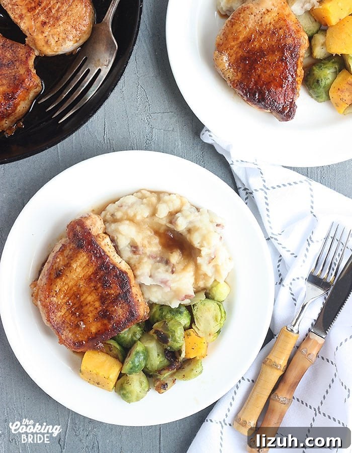 Back-to-School Dinner Ideas: Quick Family-Friendly Recipes 16 two plated pork chops with mashed potatoes and gravy and roasted vegetables on a white plate