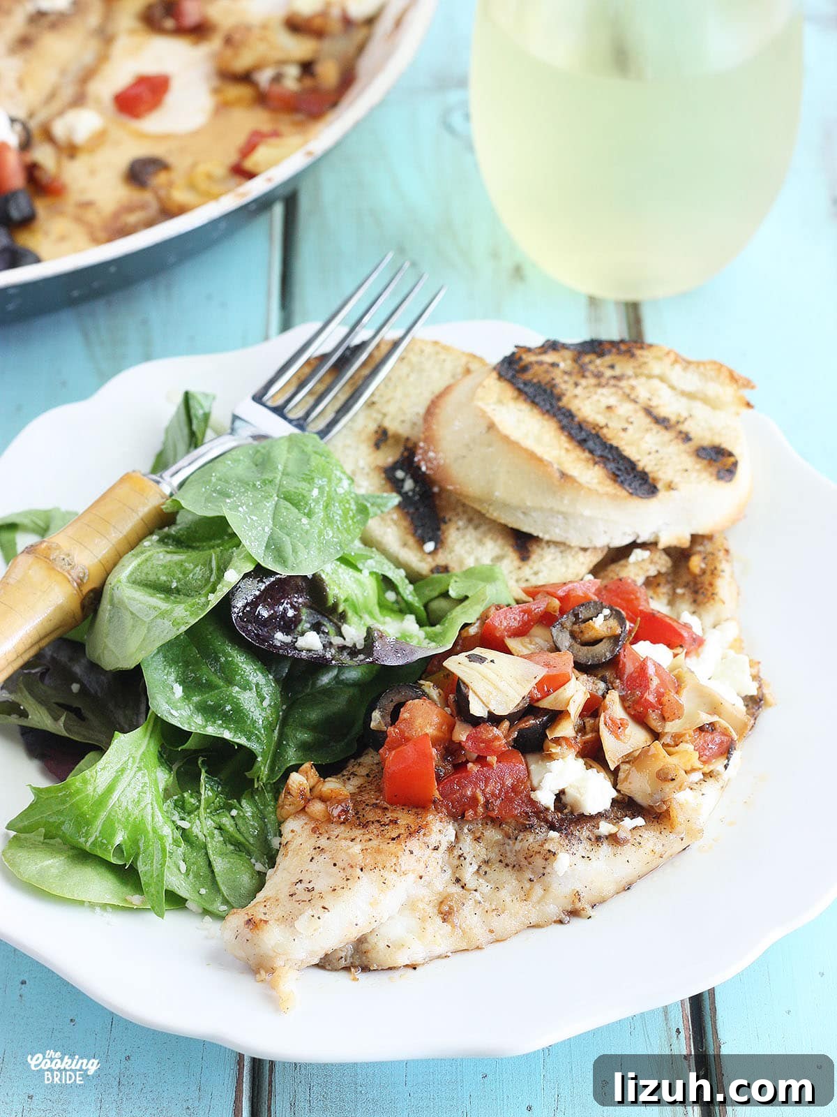 Back-to-School Dinner Ideas: Quick Family-Friendly Recipes 17 Mediterranean Catfish fillets on a white plate with a fork and toasted bread to the side