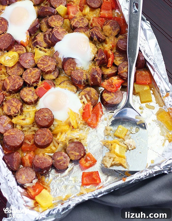Back-to-School Dinner Ideas: Quick Family-Friendly Recipes 24 Sheet pan smoked sausage bake with veggies on a foil line baking sheet and a metal spatula.