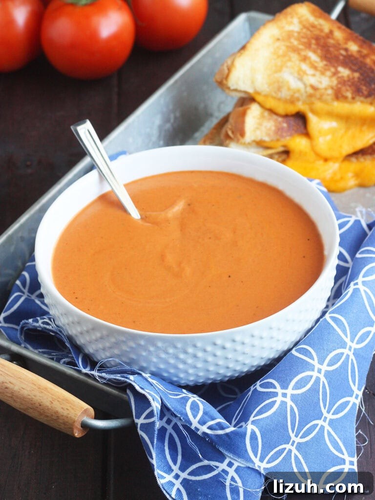 Back-to-School Dinner Ideas: Quick Family-Friendly Recipes 32 Bowl of tomato basil bisque with a gooey grilled cheese sandwich in the background.