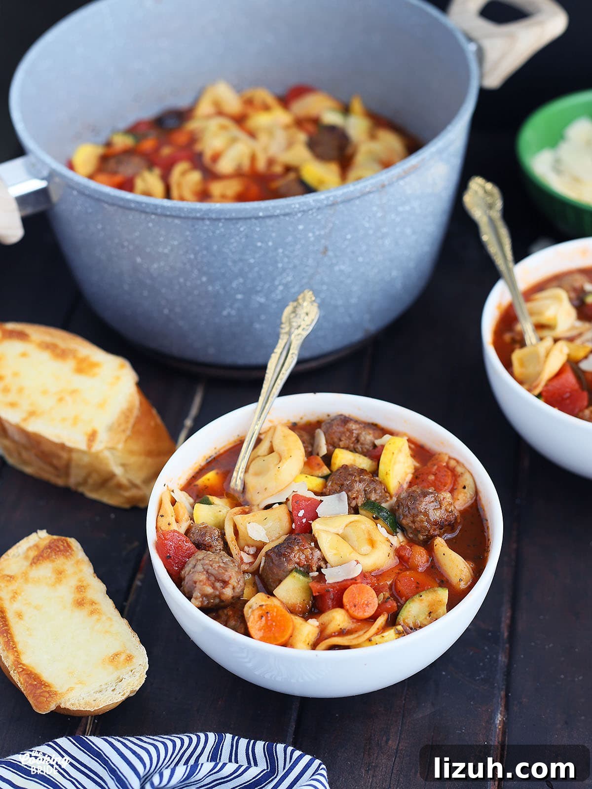 Back-to-School Dinner Ideas: Quick Family-Friendly Recipes 33 side shot of a white bowl of meatball tortellini soup with two slices of cheese toast to the side.