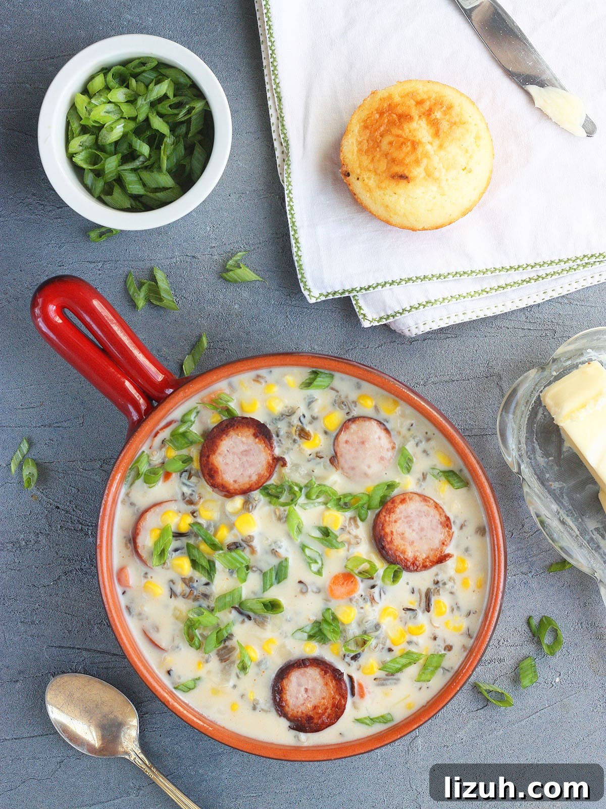 Back-to-School Dinner Ideas: Quick Family-Friendly Recipes 35 Serving of smoked sausage corn chowder garnished with green onions. A bowl of sliced green onions and a corn muffin are seen to the side.