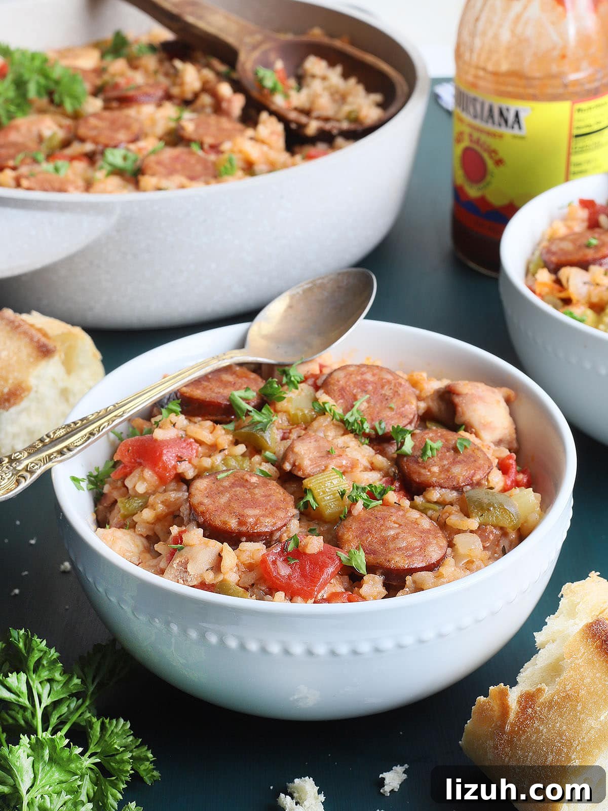 Back-to-School Dinner Ideas: Quick Family-Friendly Recipes 40 white bowl of chicken jambalaya with a pan, hot sauce and crusty bread in the background