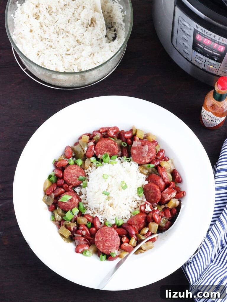 Back-to-School Dinner Ideas: Quick Family-Friendly Recipes 44 Dish of Instant Pot red beans and rice with an Instant Pot electric pressure cooker and a serving bowl of cooked rice in the background.