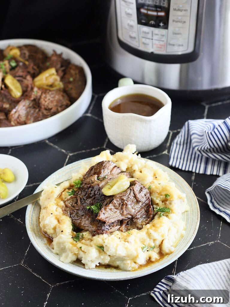 Back-to-School Dinner Ideas: Quick Family-Friendly Recipes 45 Instant Pot Mississippi Pot Roast served over a bed of mashed potatoes and gravy. A gravy boat, serving dish with roast, a small dish of peppers and an Instant Pot are seen in the background.