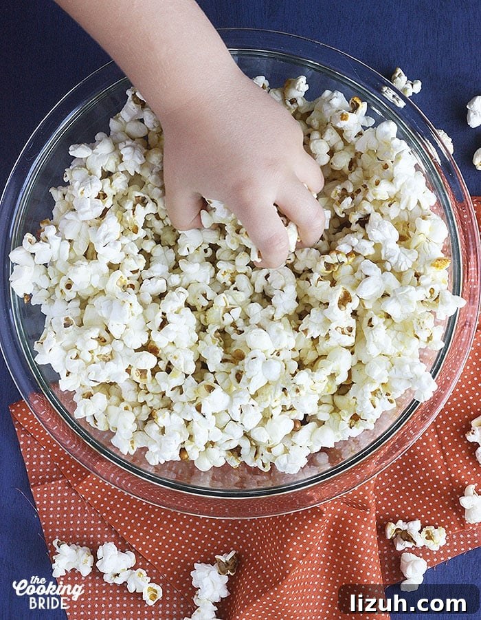 Back-to-School Dinner Ideas: Quick Family-Friendly Recipes 55 little hand reaching into a glass bowl full of homemade kettle corn