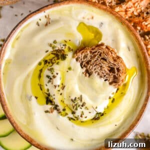 Thick and smooth whipped cottage cheese dip with golden olive oil, paired with crunchy seeded bread and fresh vegetables.