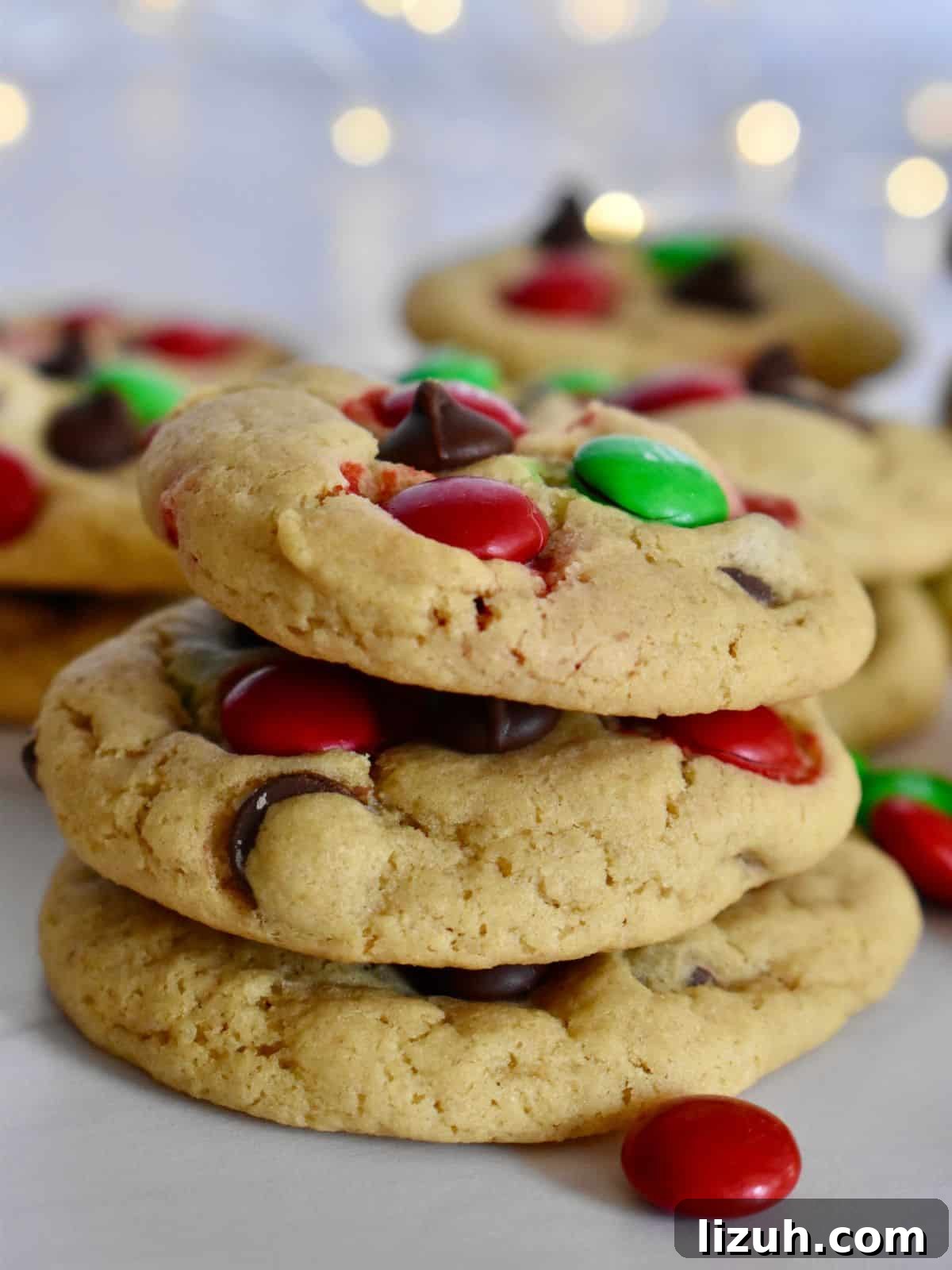 Christmas M&M Cookies Recipe: Festive, Chewy Holiday Cookies 2 Christmas M&M cookies stacked on each other on a white countertop.