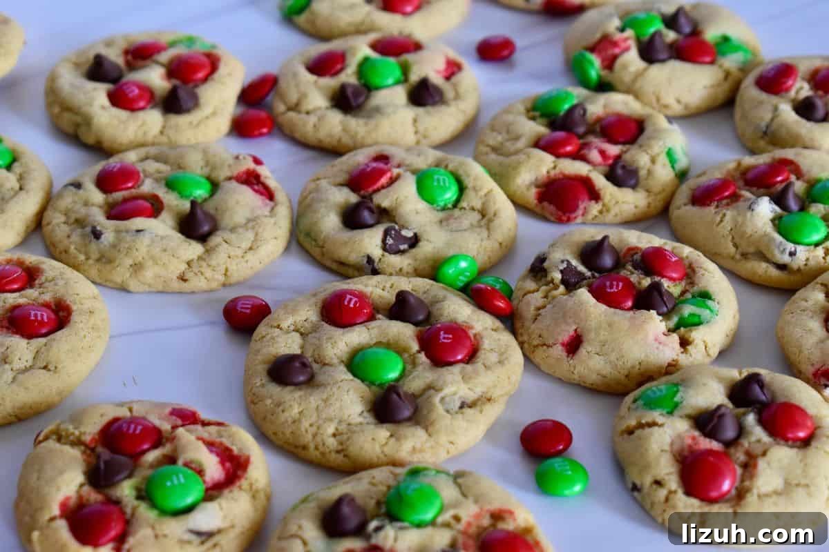 Christmas M&M Cookies Recipe: Festive, Chewy Holiday Cookies 6 Christmas M&M Cookies with green and red M&Ms on a white surface.