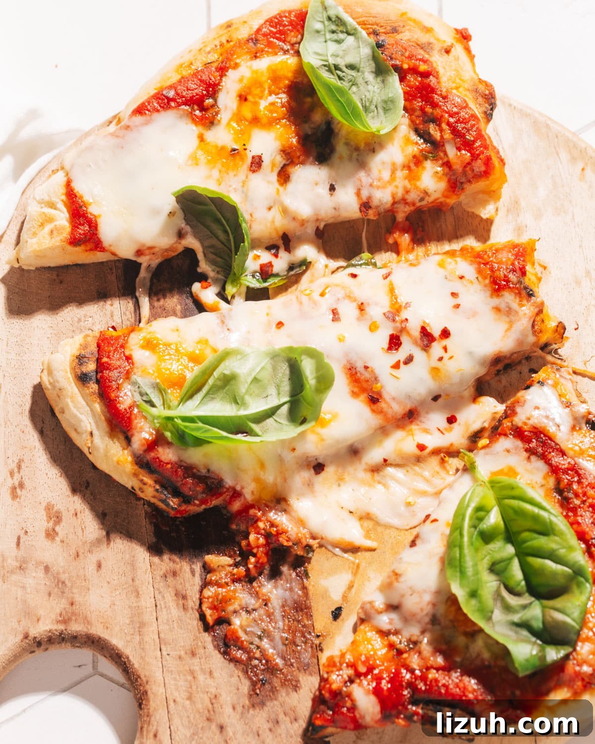 15-Minute Naan Pizza Recipe: Quick Homemade Pizza on Naan 2 Naan Pizza sliced on cutting board.