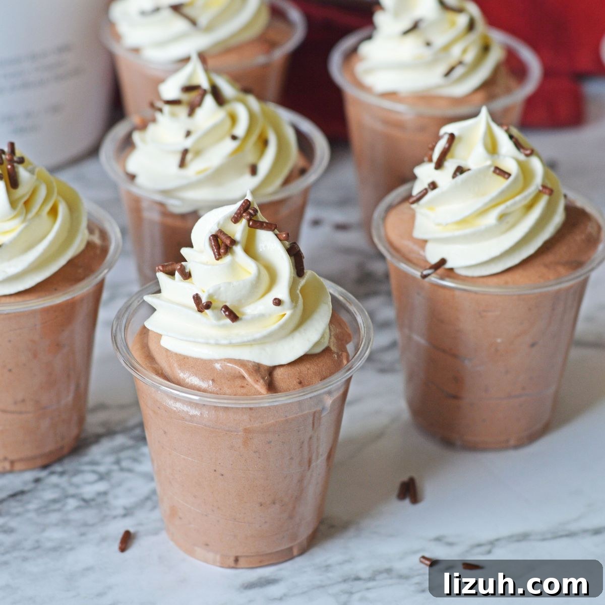 Rumchata Pudding Shots on table with whipped cream on top of each one 
