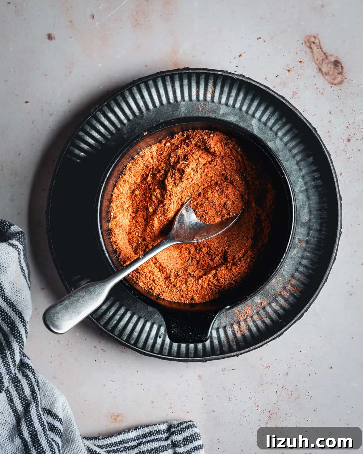 Homemade Blackened Seasoning Mix for Bold, Flavorful Dishes 4 Blackened Seasoning in a black bowl with a silver spoon photographed from the top.