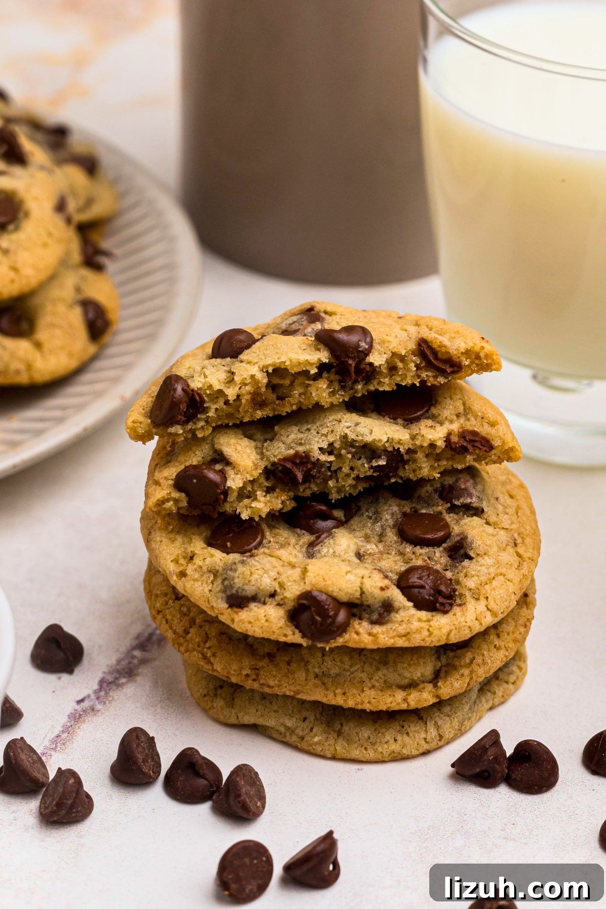 Stacked cookies on a marble table in front of milk. 
