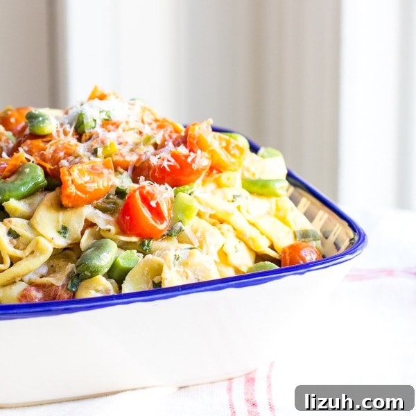 April Vegetarian Meal Plan: Week 4 Recipes & Grocery List 5 A blue dish heaped with cheese tortellini, tomatoes and fava beans.