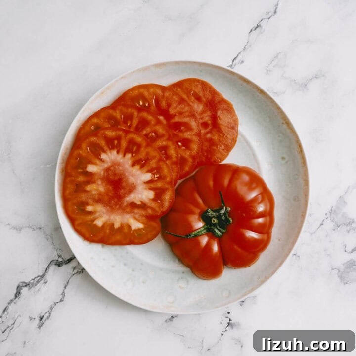 Sliced heirloom tomatoes on a plate, ready for making halloumi salad.