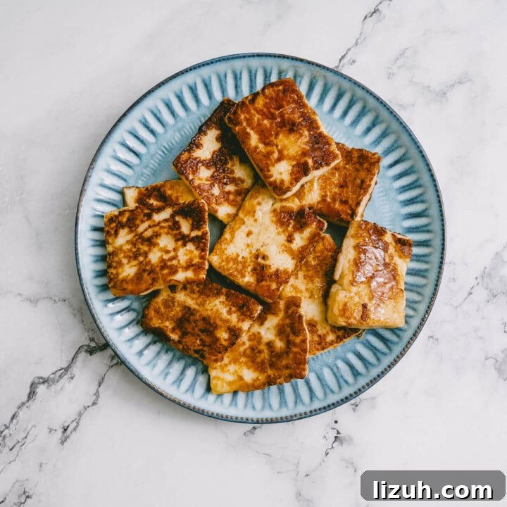 Golden brown halloumi slices on a blue plate, ready to be used in salad.