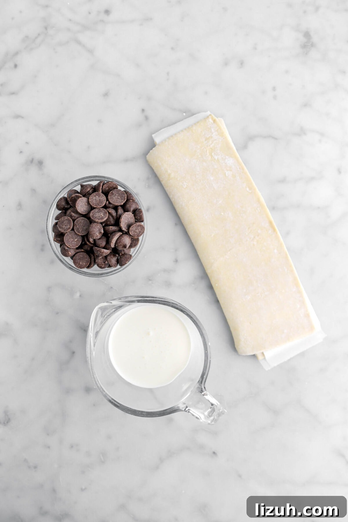 puff pastry, chocolate chips, and heavy cream on marble surface.