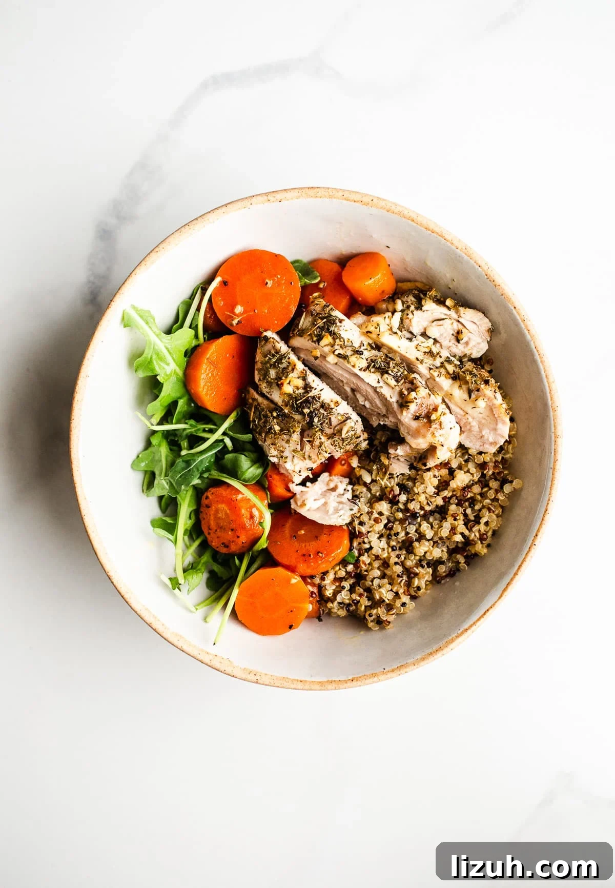 Roasted Carrot and Chicken Quinoa Bowl with Lemon-Tahini Drizzle 2 Quinoa, carrots, and baked chicken in a bowl.