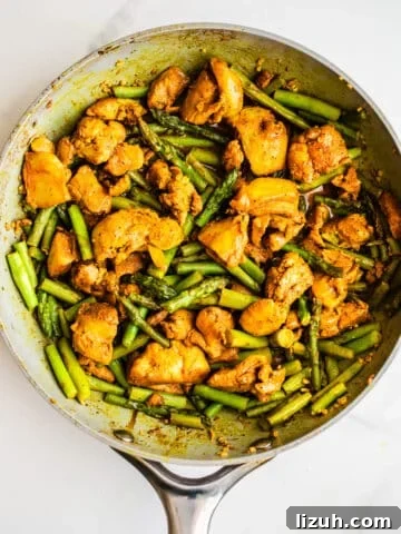 Chicken and asparagus in a pan.