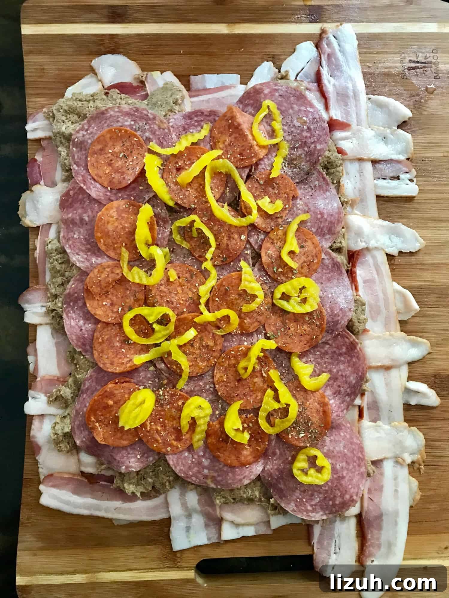Bacon Explosion Pizza: Stuffed Crust Pizza Fatty Recipe 3 Bacon weave topped with meat and peppers on wooden cutting board overhead shot