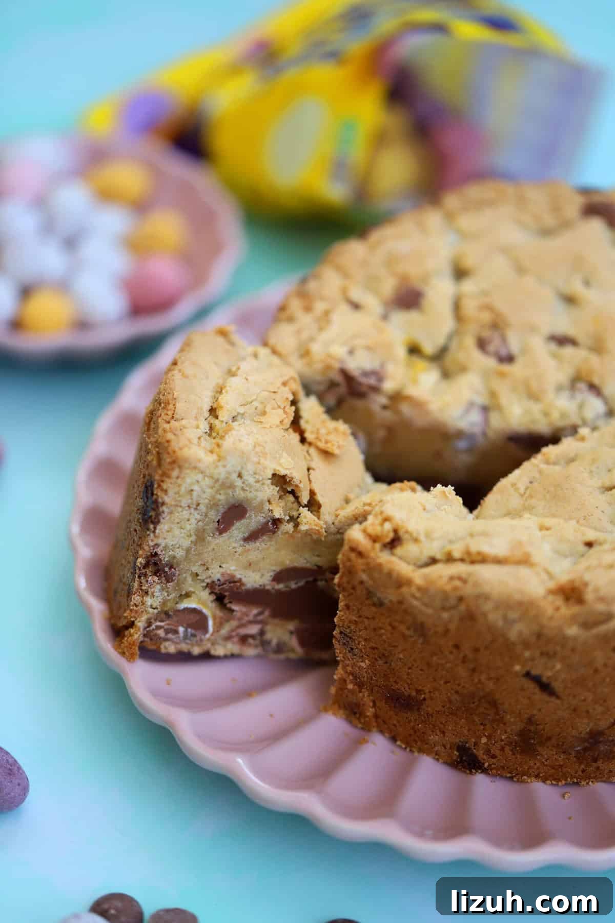 Mini Egg Cookie Pie Recipe: Creamy No-Bake Easter Dessert 2 A Mini Egg Cookie Pie with a wedge taken out of it, on a pink plate.